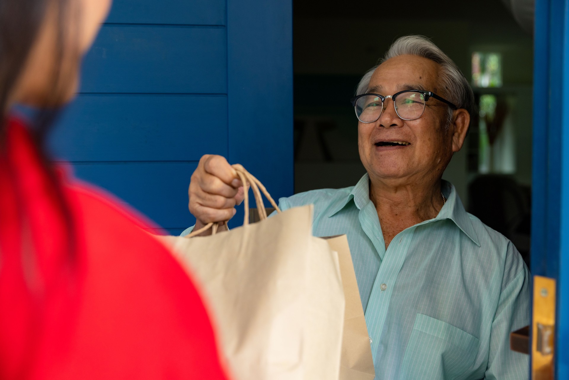 Woman delivery food to senior at home.